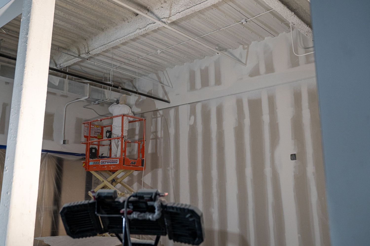 Interior of unfinished commercial space showing construction progress with white walls.