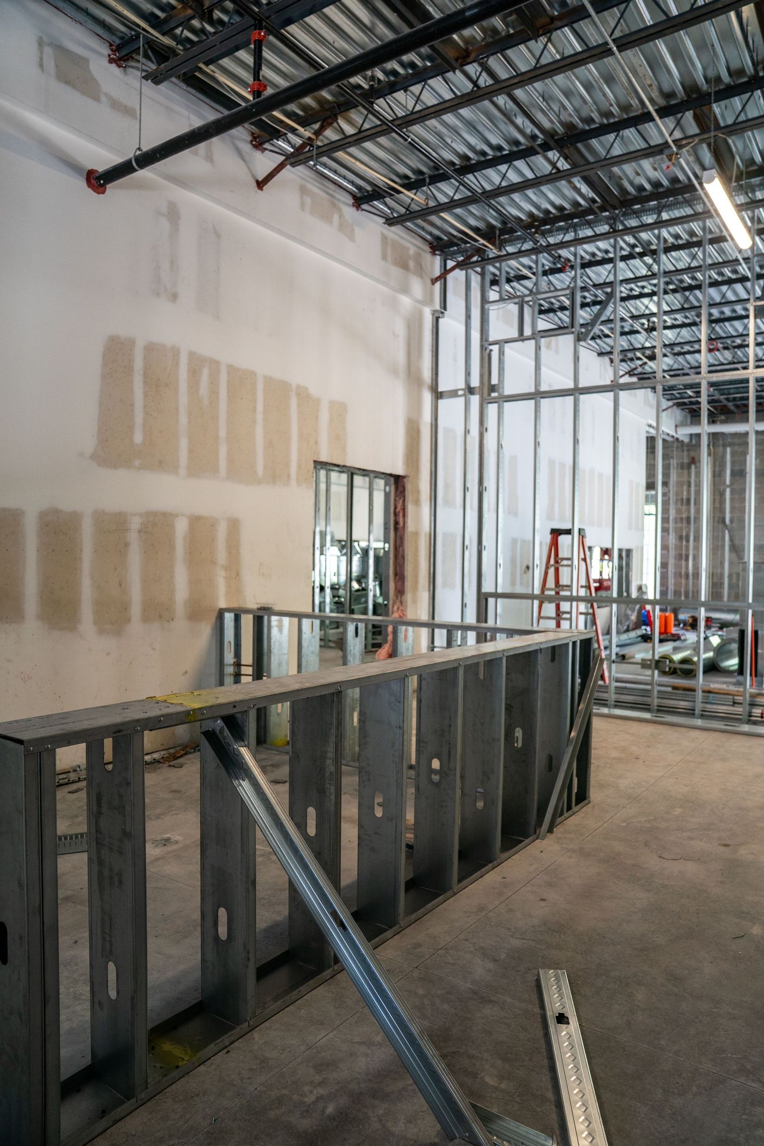 Partially completed interior with metal framing and drywall installation in progress.