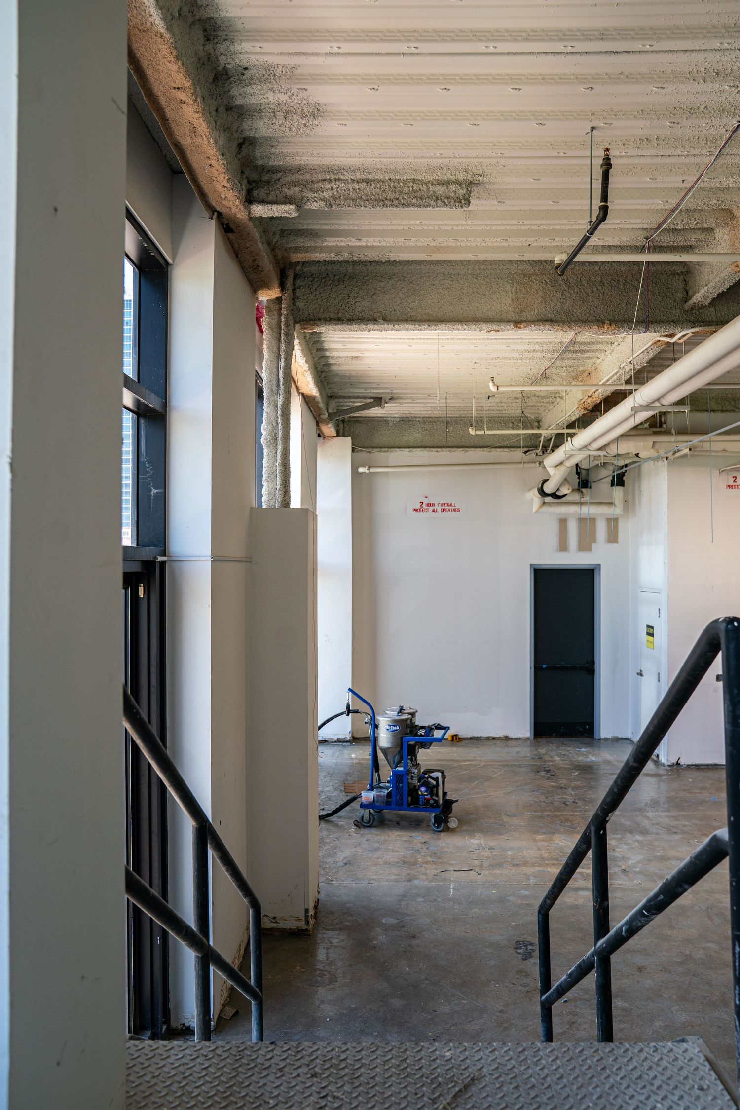 Large open warehouse space with white support columns and dark angled braces along the walls.