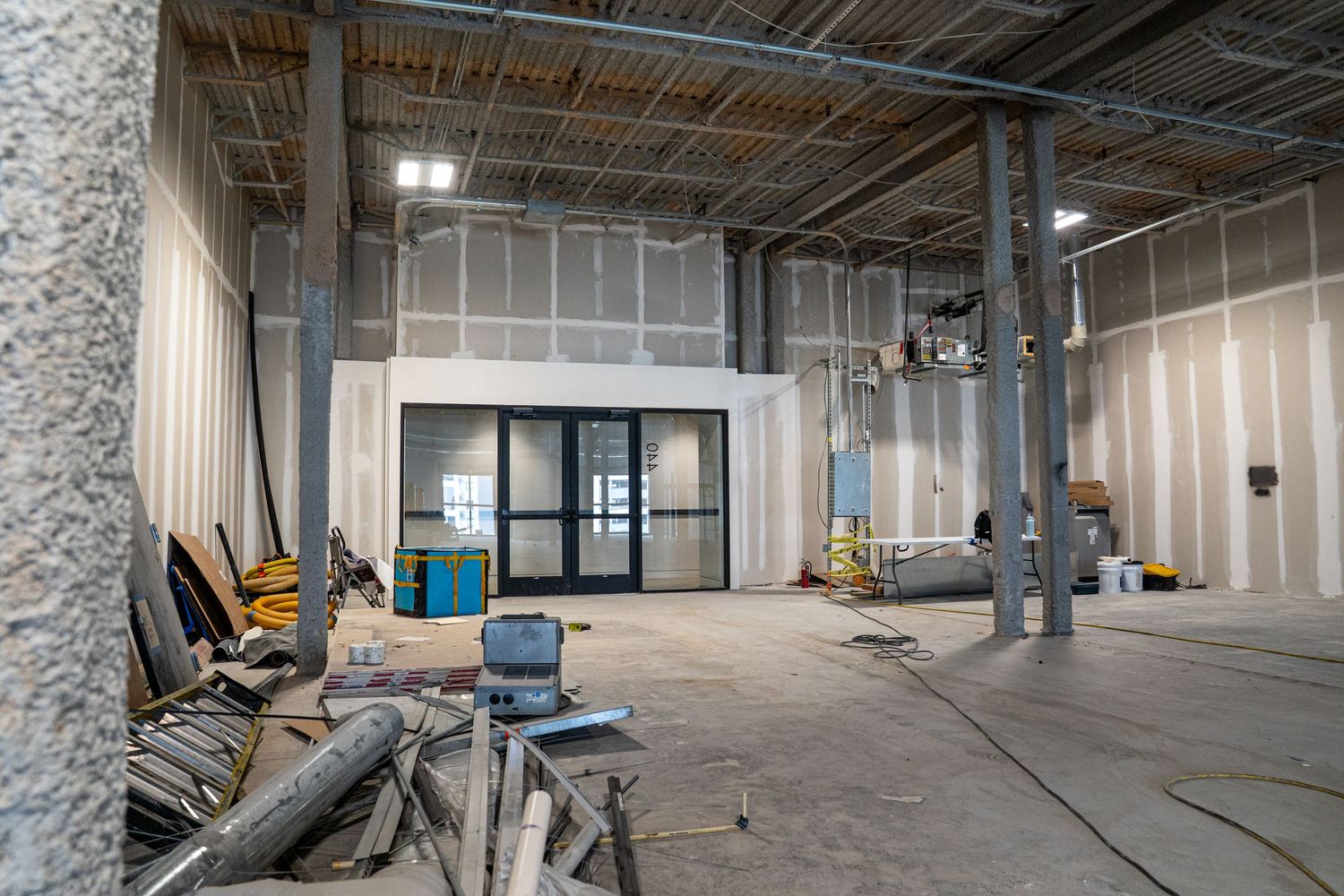 Commercial space under construction with metal support columns and exposed building materials.