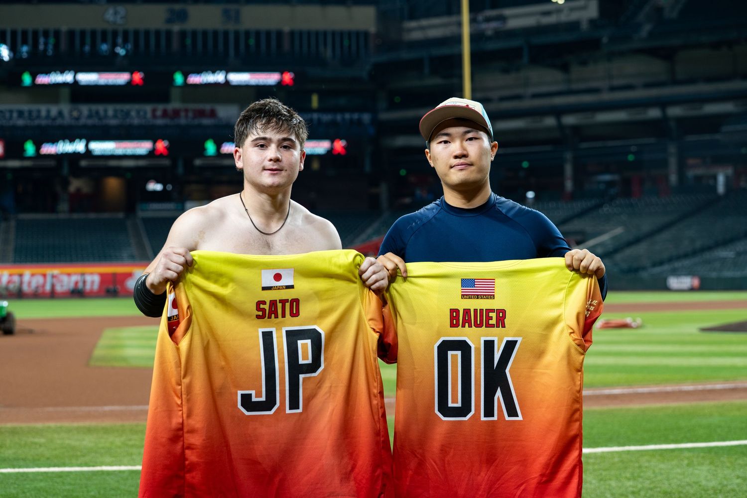 Baseball players in yellow jerseys pose together on the field during a game.