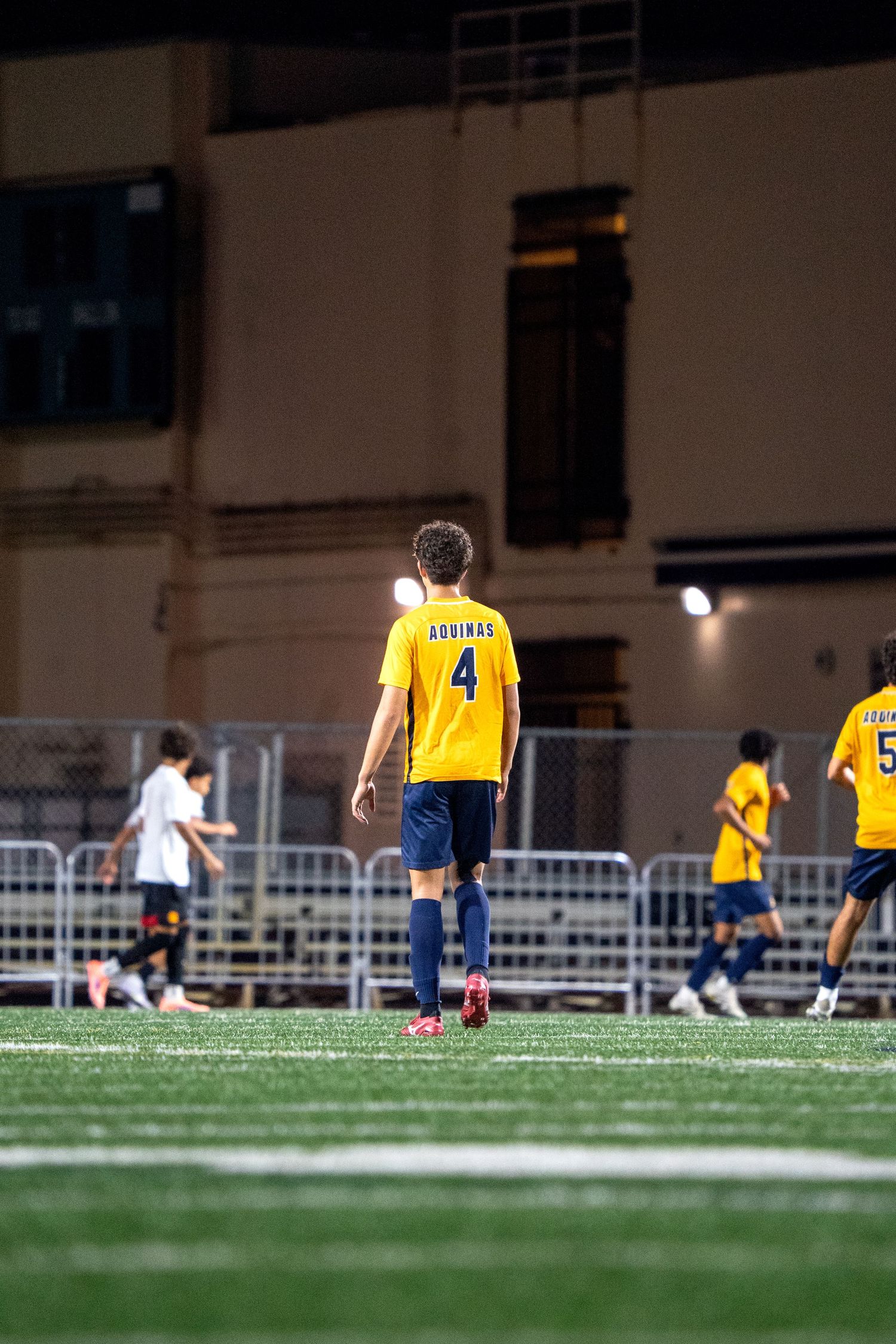 Soccer players in yellow jerseys spread out across a practice field during training.