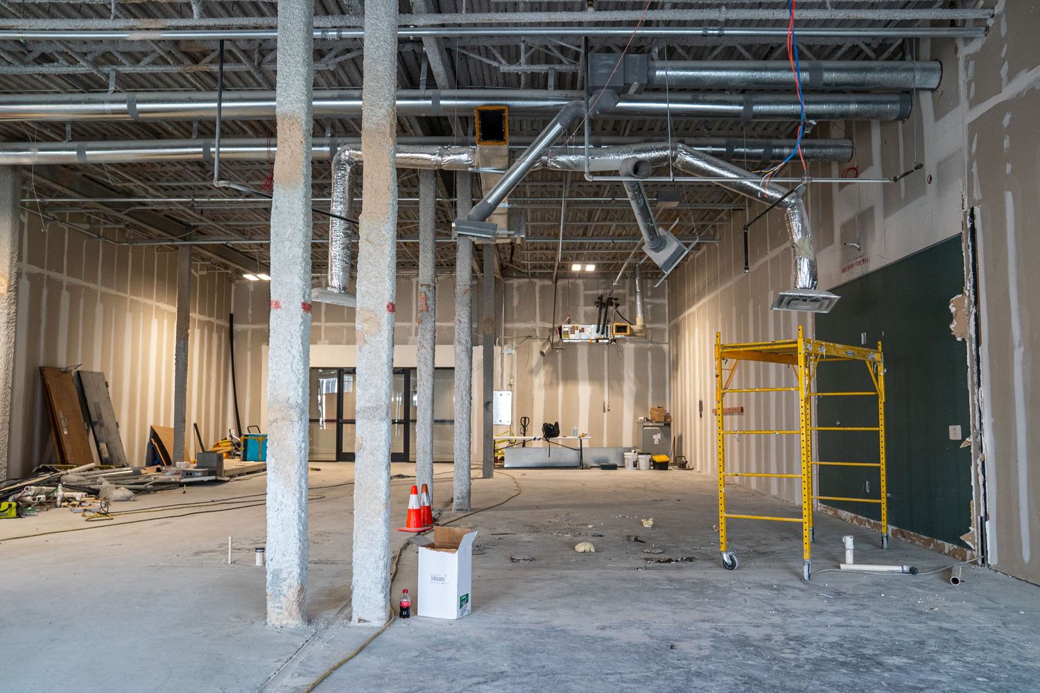 Commercial renovation project showing extensive open floor plan and ceiling work in progress.