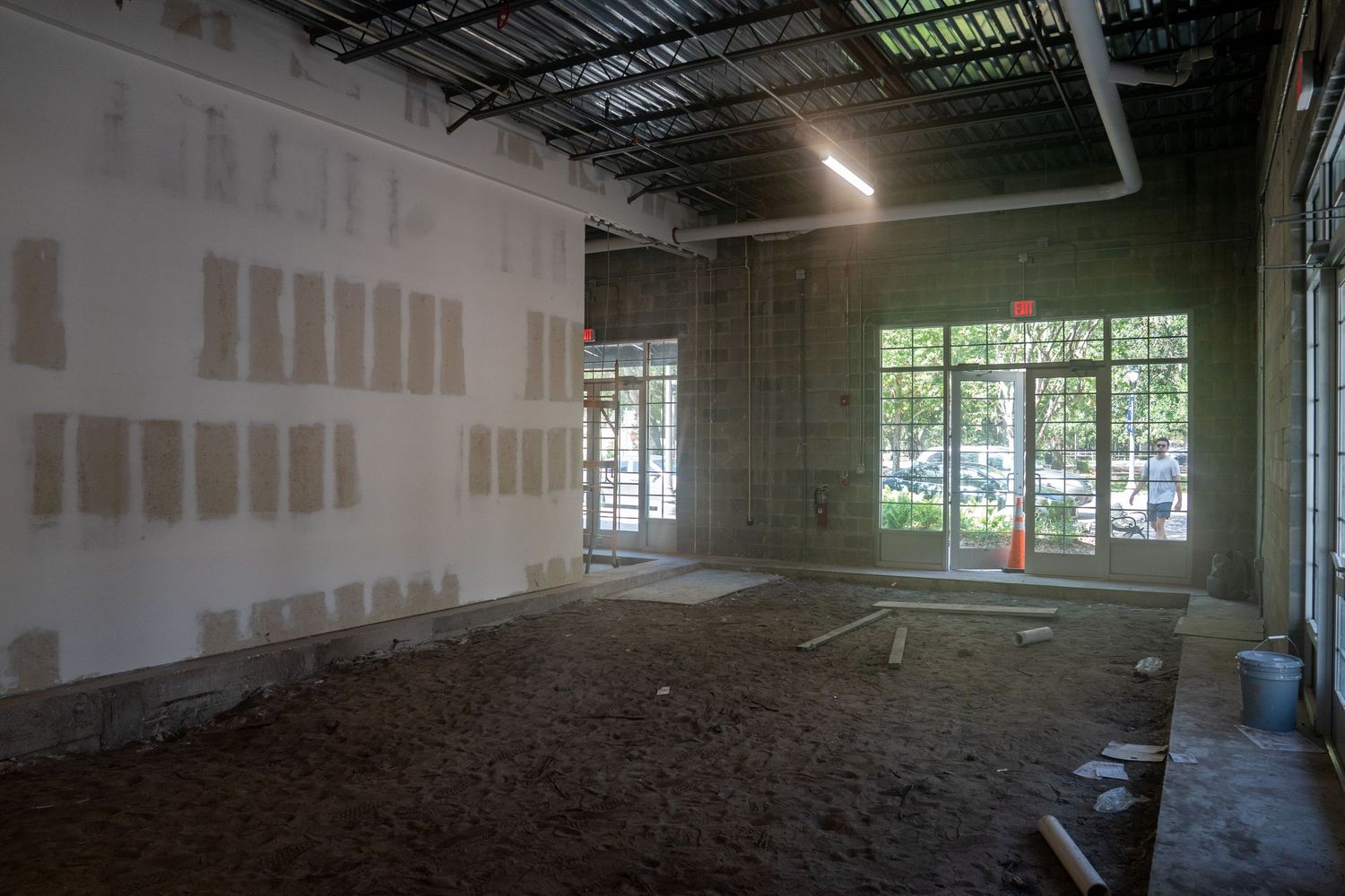 Unfinished room with dirt floor and drywall showing window openings and exposed ceiling.