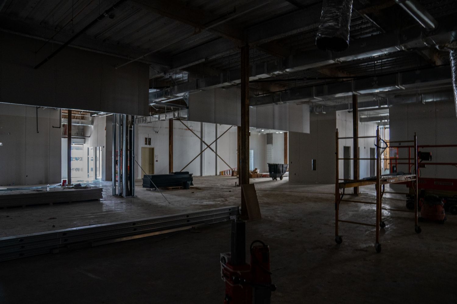 Industrial space under construction with scaffolding and exposed building infrastructure.