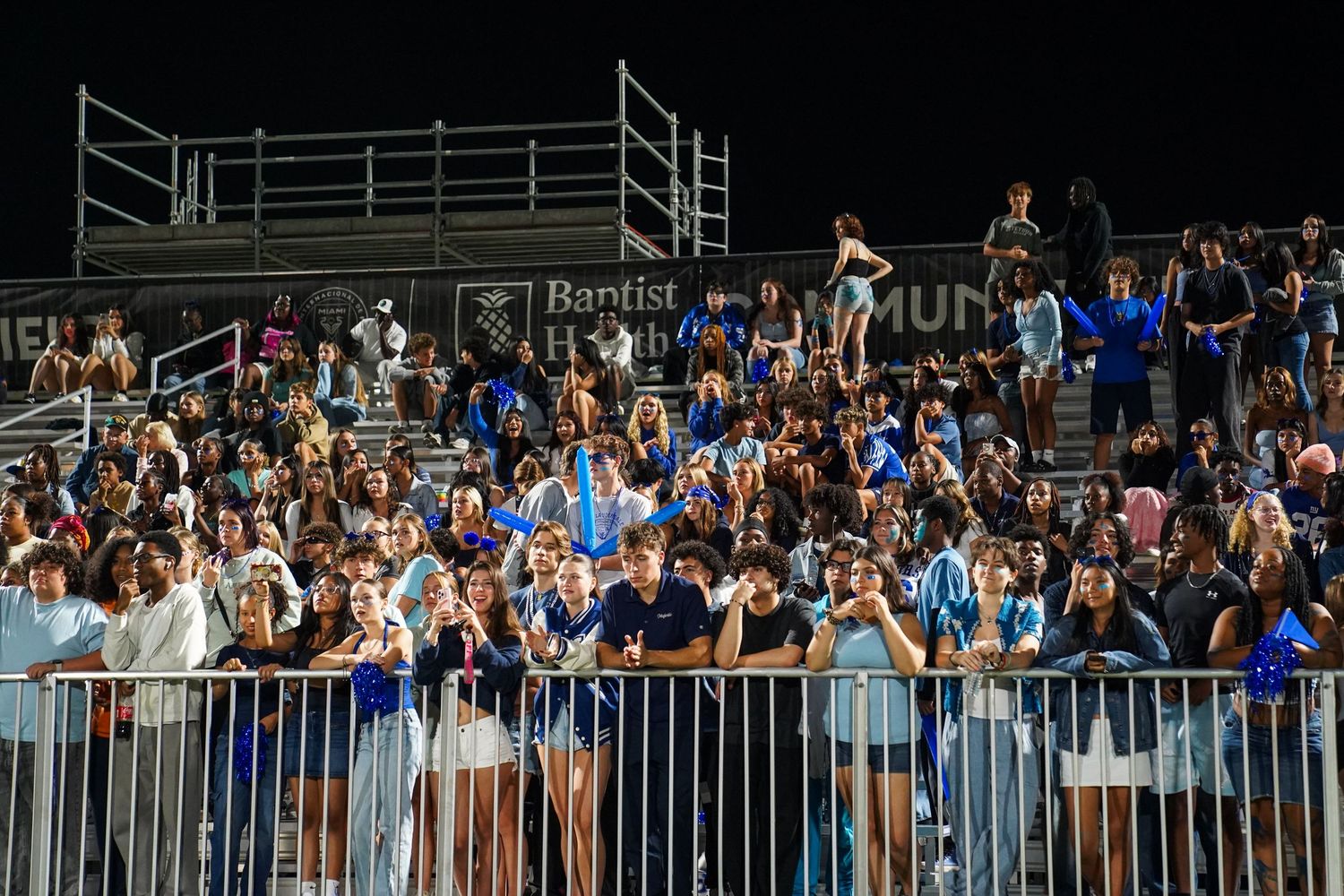 Spectators fill bleacher seats at a nighttime outdoor stadium event.