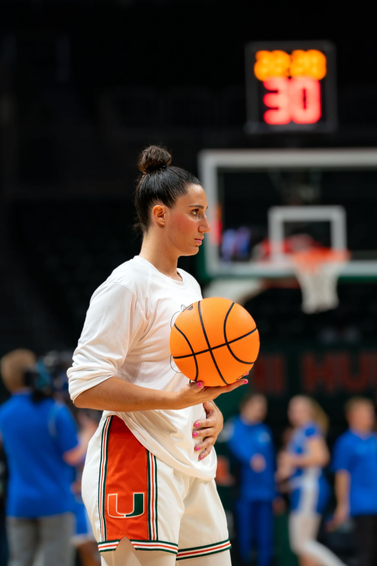 Players hold basketballs during warmup at a Miami Hurricanes basketball game.