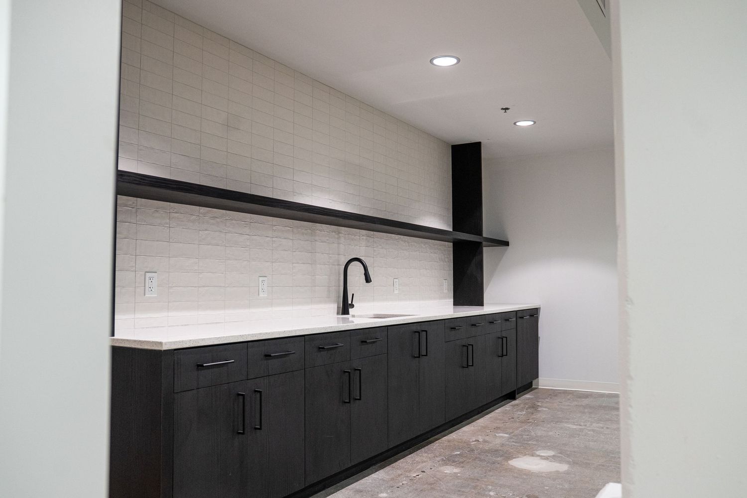 Modern office space with sleek black cabinets installed along white walls.