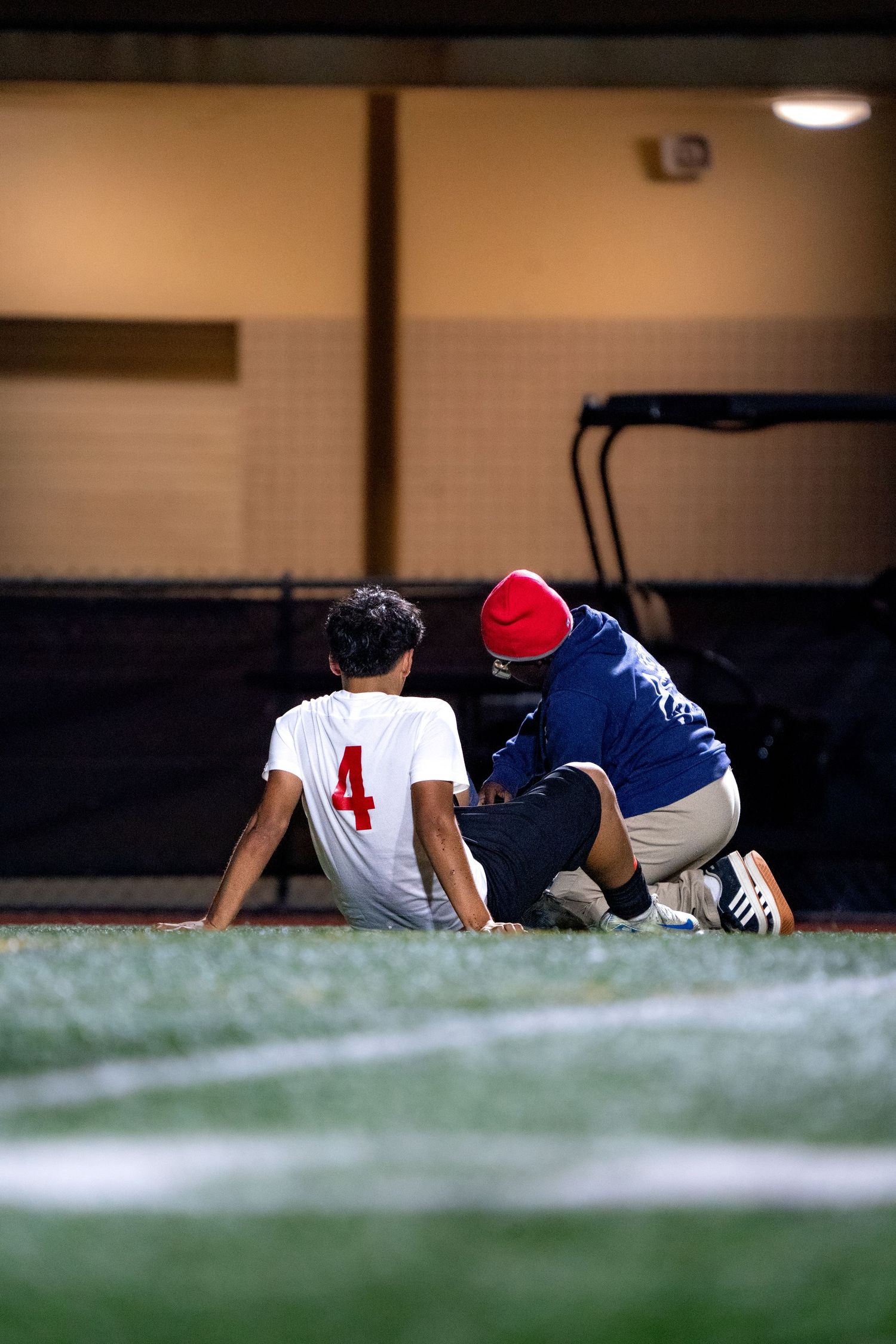 Athletes resting on ground during sports practice or game.