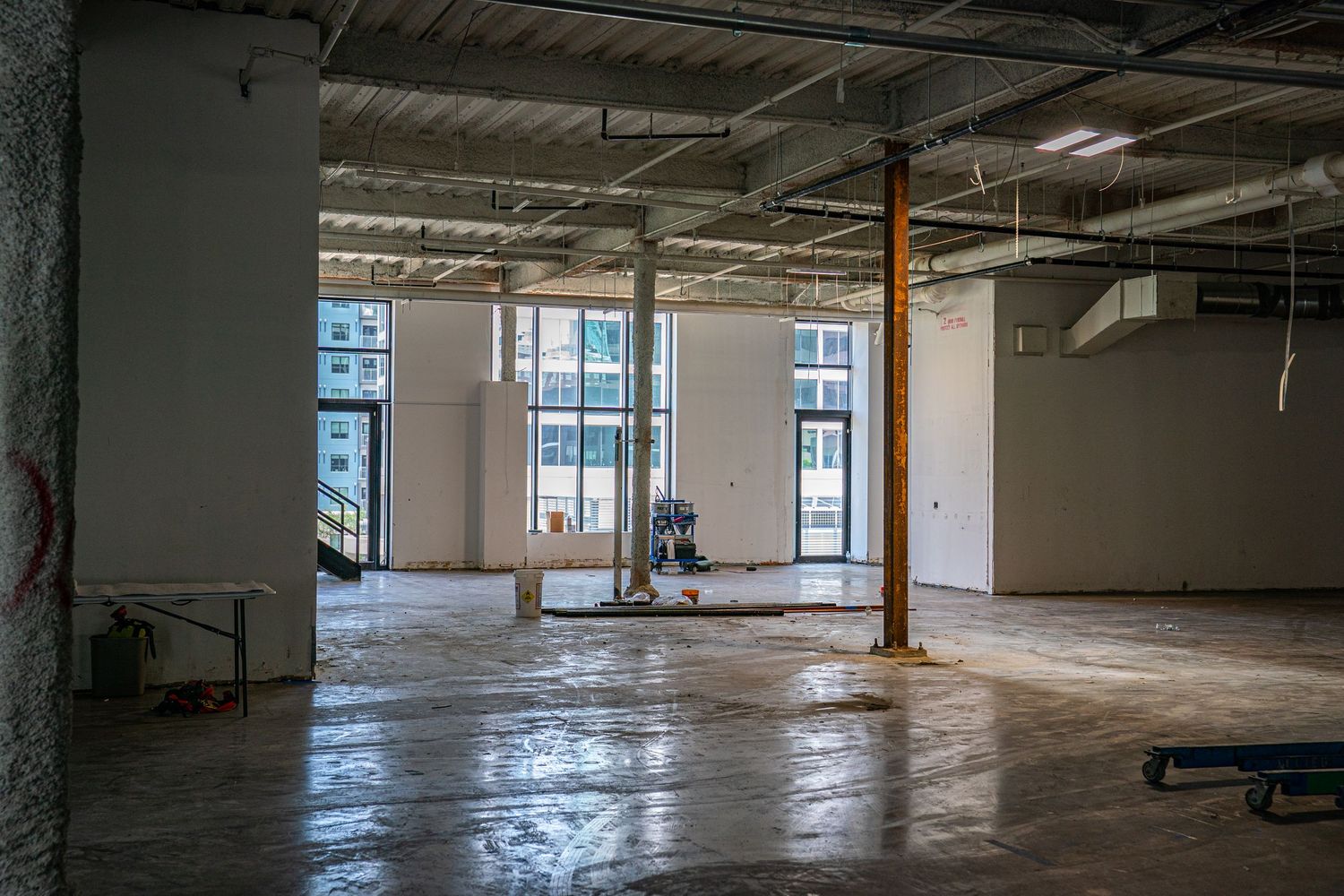 Expansive empty warehouse interior showing structural columns and mechanical systems.