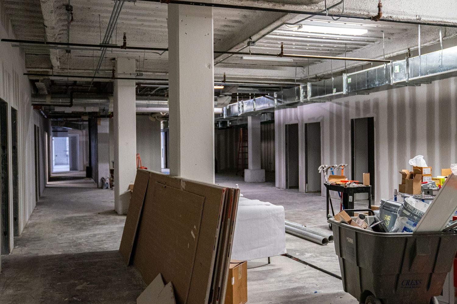 Large open floor plan showing construction progress with scattered building materials.