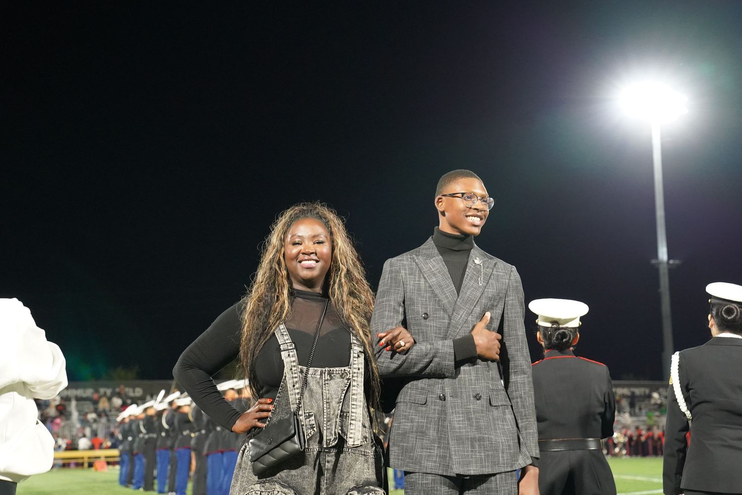 Group gathered for a nighttime outdoor event under bright stadium lights.