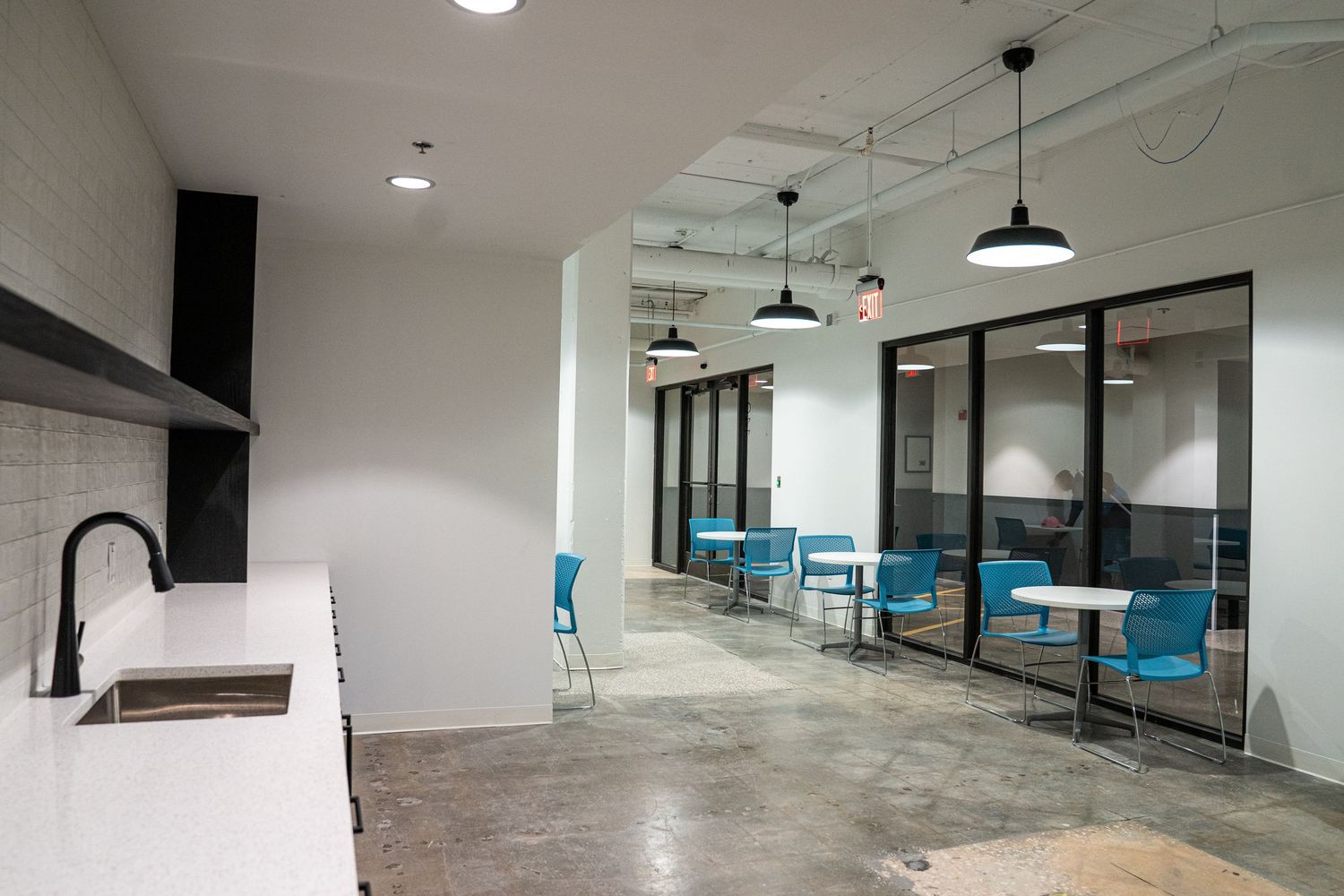 Modern office renovation with exposed mechanical systems and contemporary lighting design.