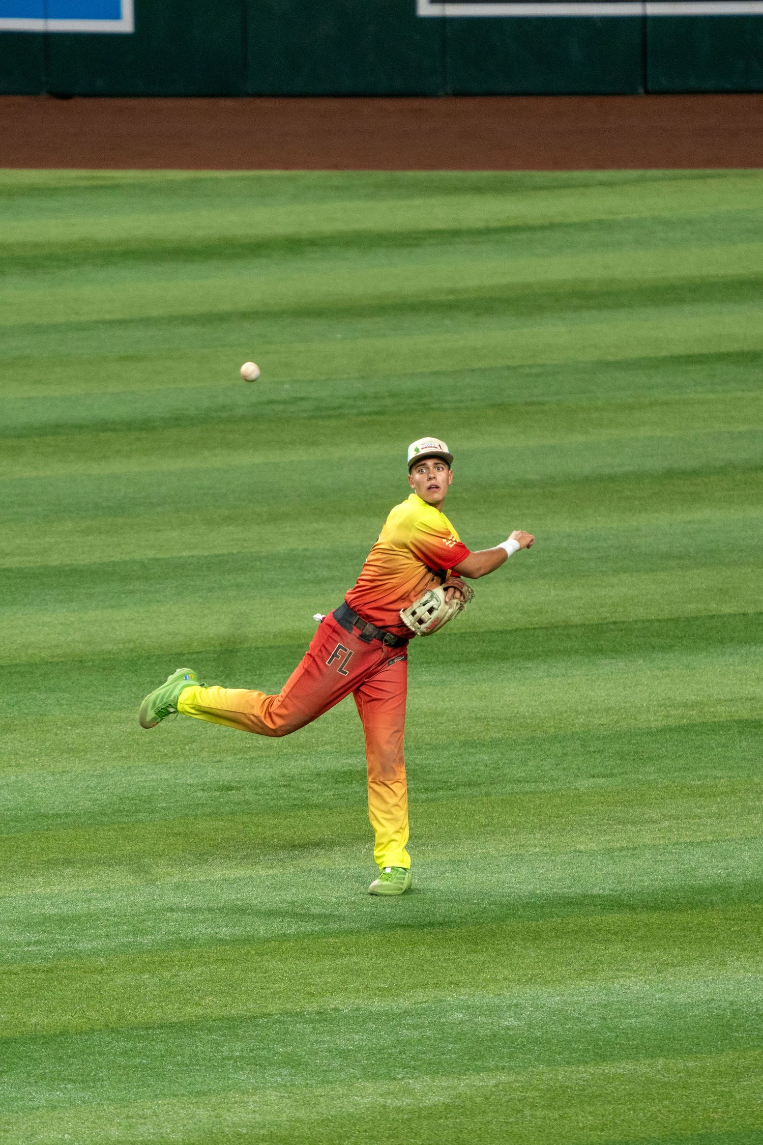 A sequence showing a baseball player diving across the outfield grass to make a catch.