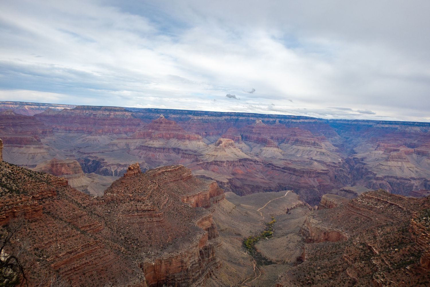 Panoramic vista of the Grand Canyon showing layered rock formations and distant plateaus.
