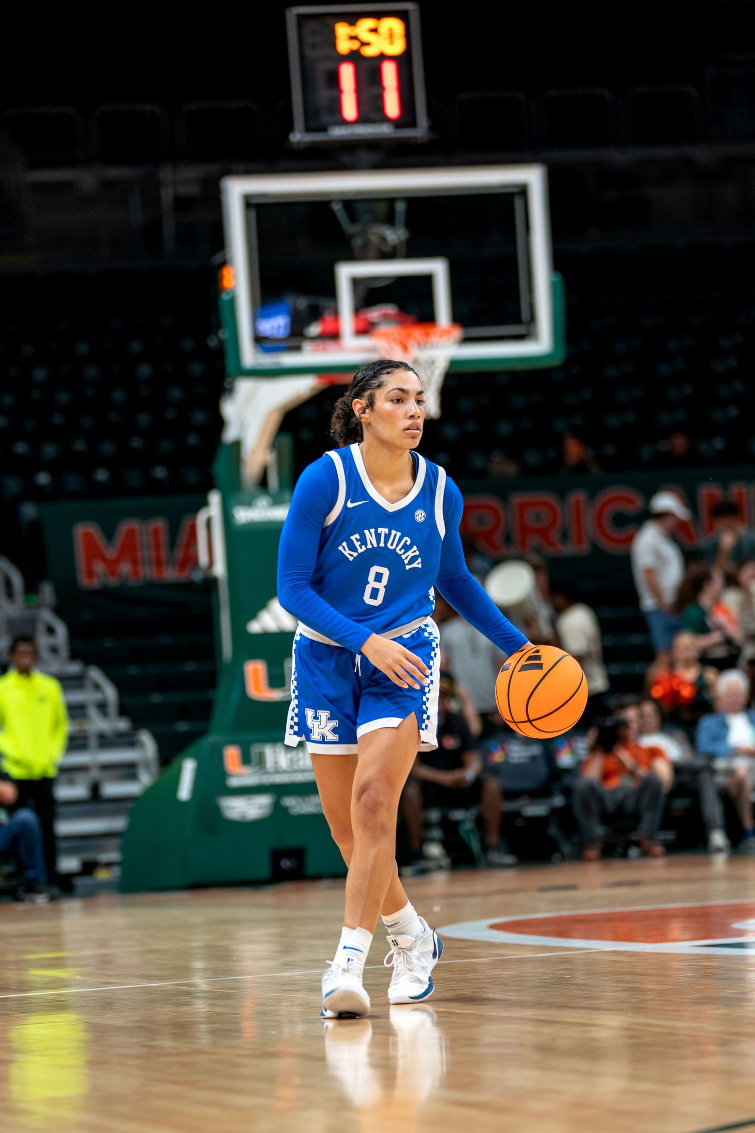 Basketball player in blue Kentucky jersey dribbles on court during game.