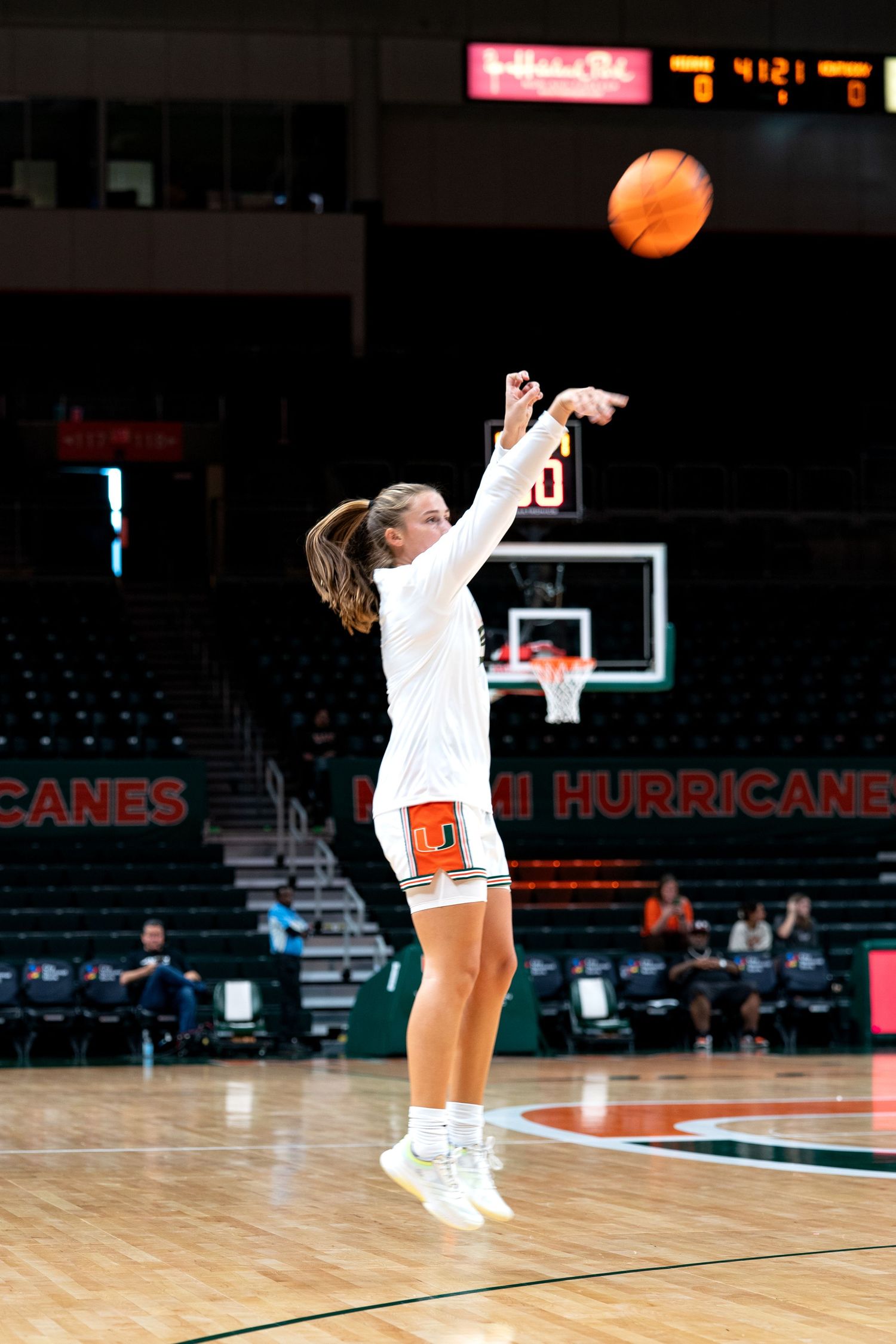 Basketball players practicing shooting drills on a court with Hurricanes branding visible.