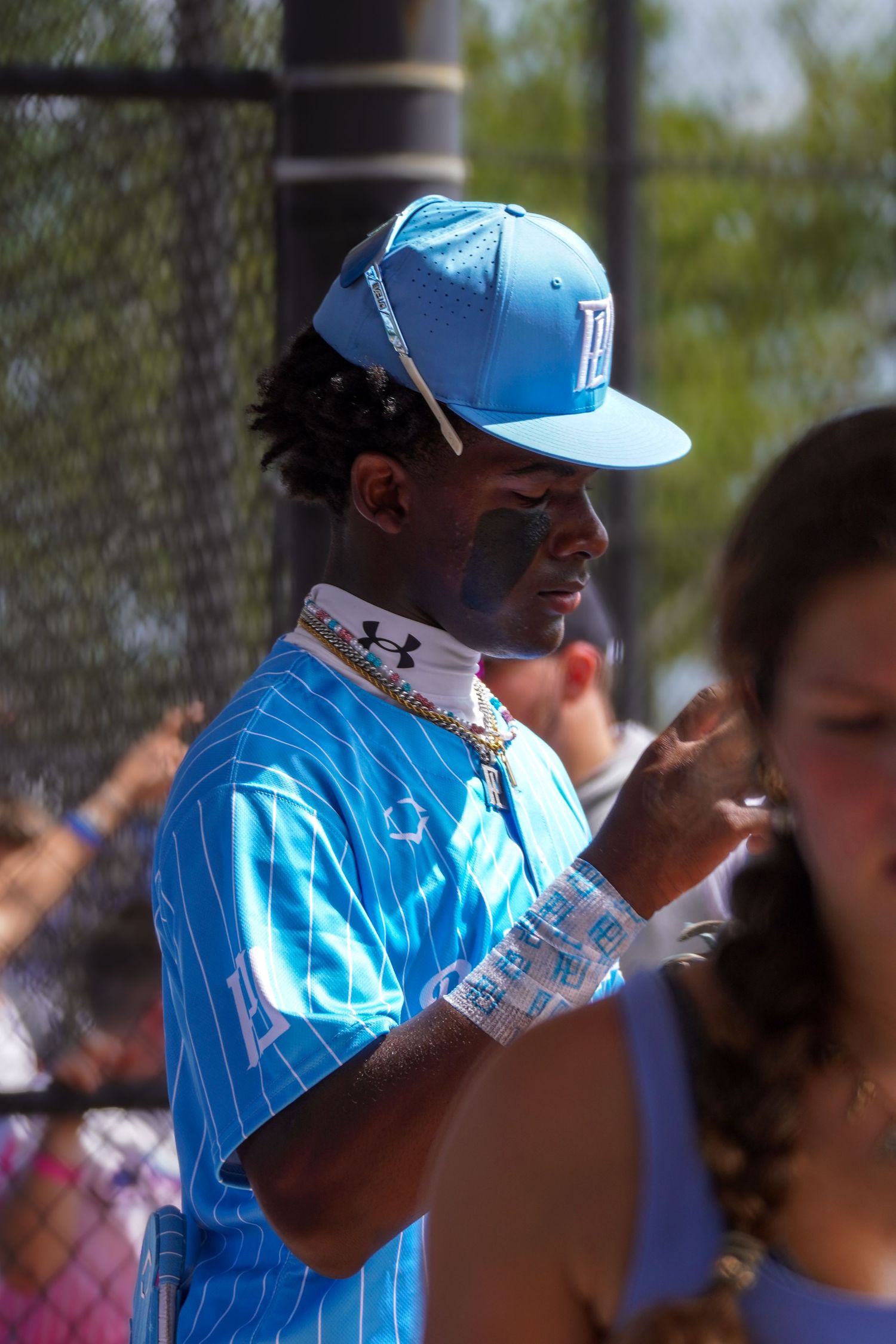 Baseball coach in light blue uniform giving instructions during a game.