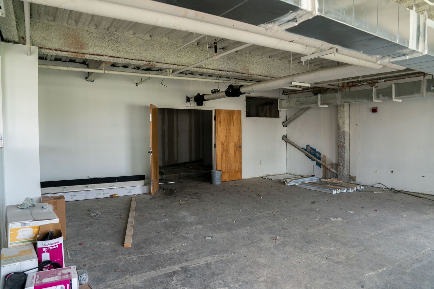 Expansive commercial renovation space with concrete floors and industrial ceiling.