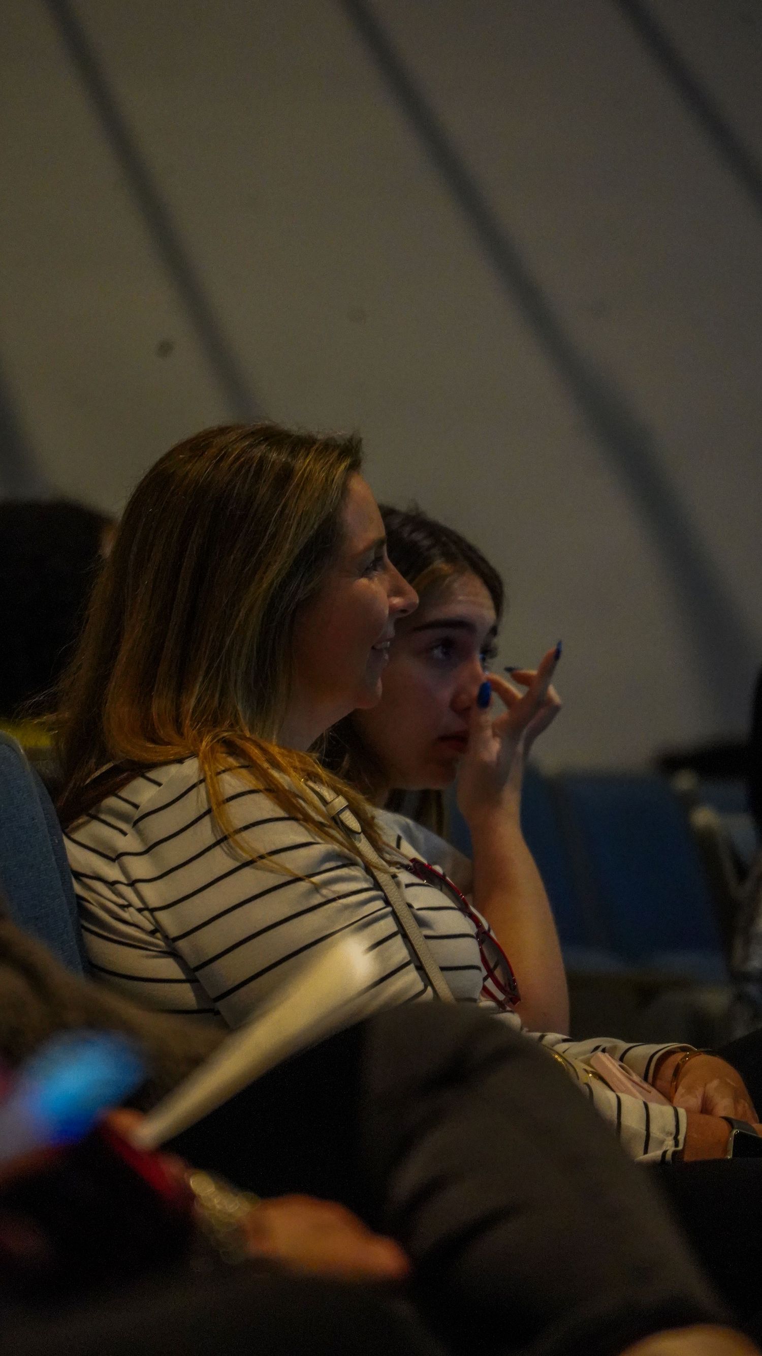 Audience members in theater seats engaged in watching a performance.