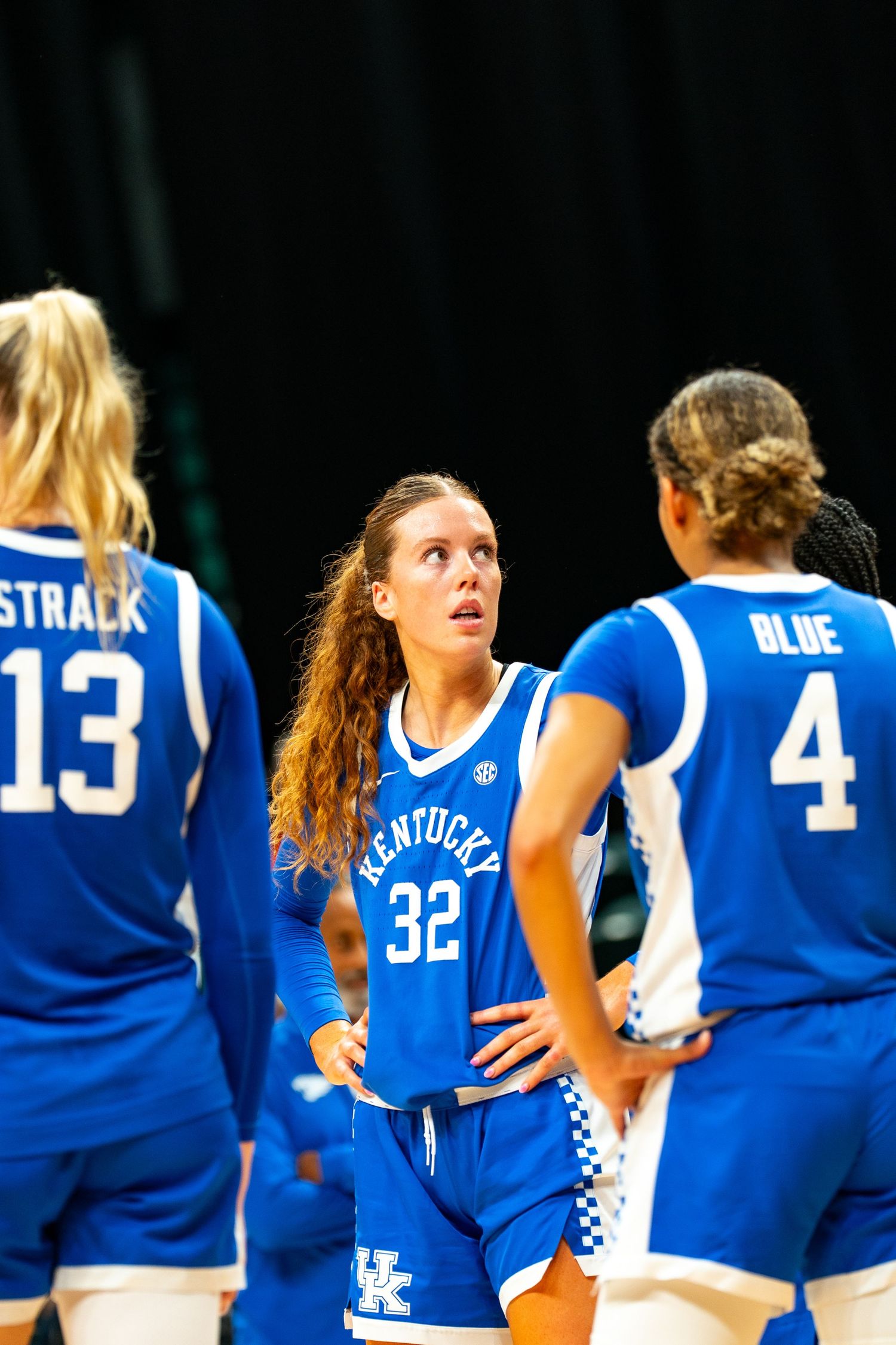 Kentucky women's basketball team lines up in blue jerseys during game.