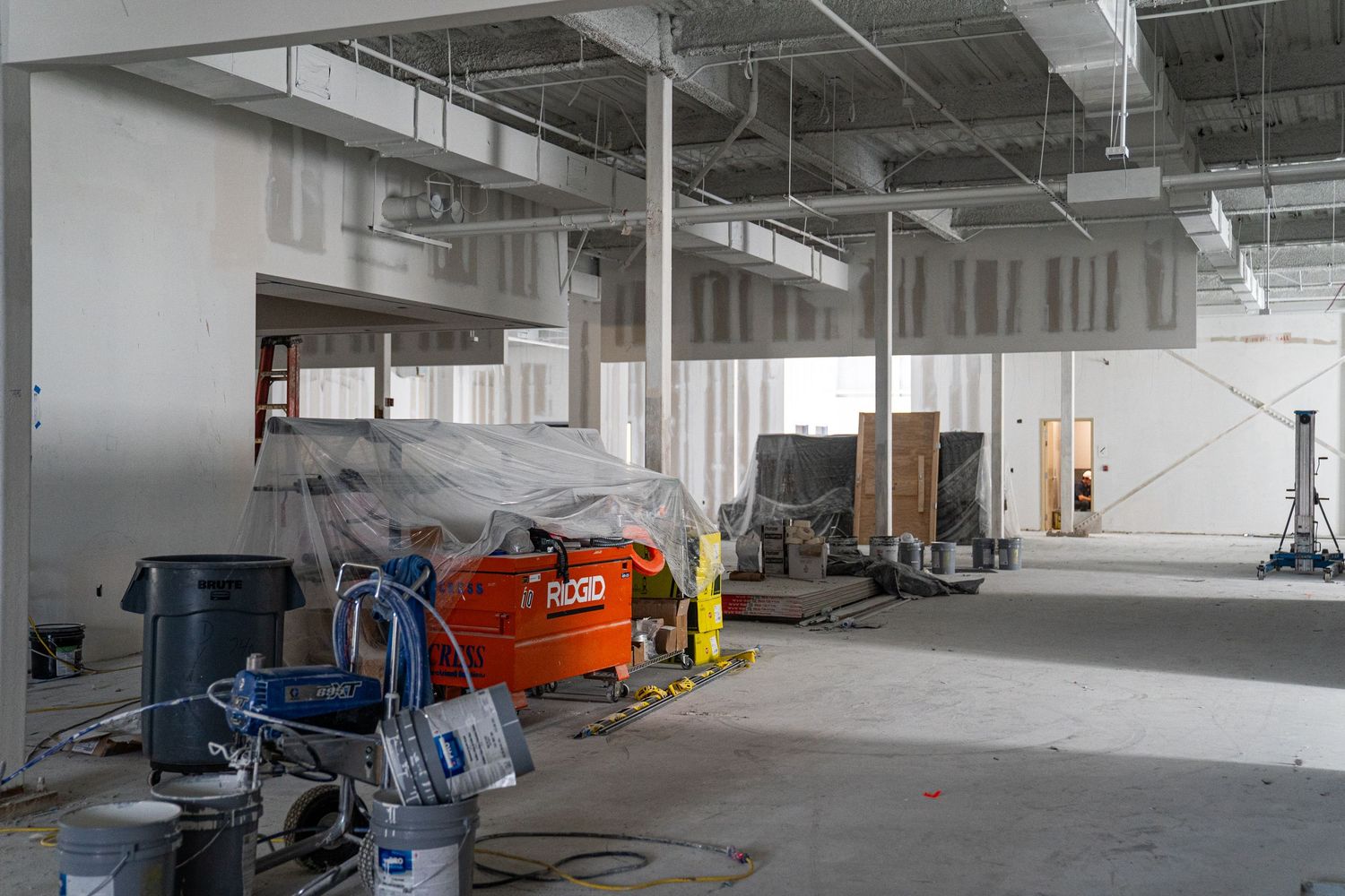 Large industrial space with construction equipment and exposed building infrastructure.