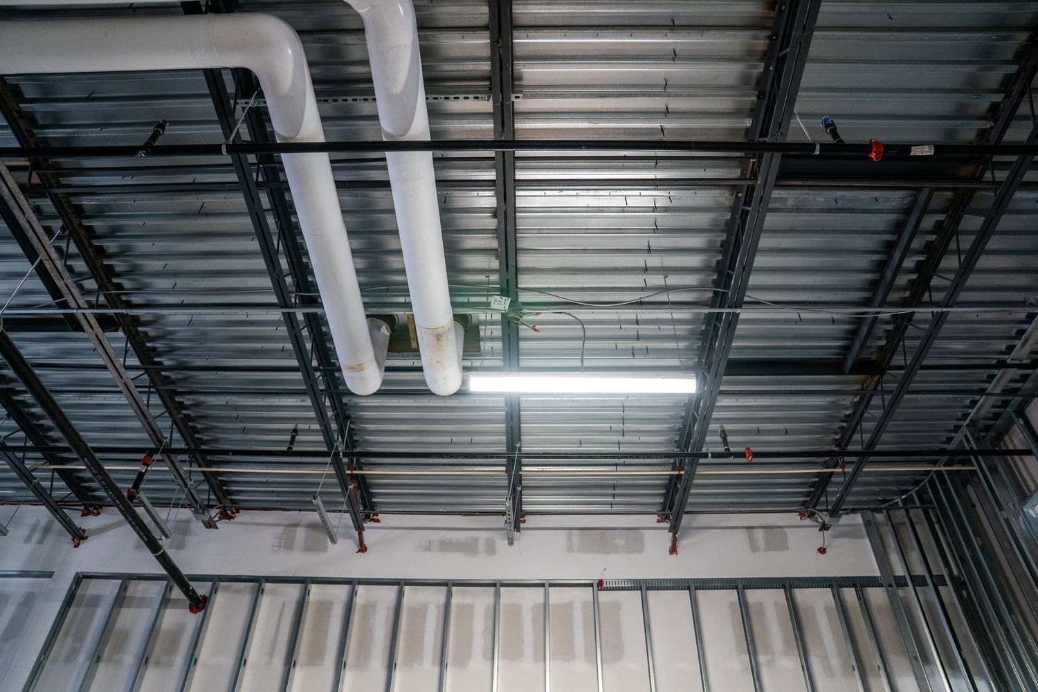 Industrial ceiling infrastructure and ductwork visible during commercial construction phase.