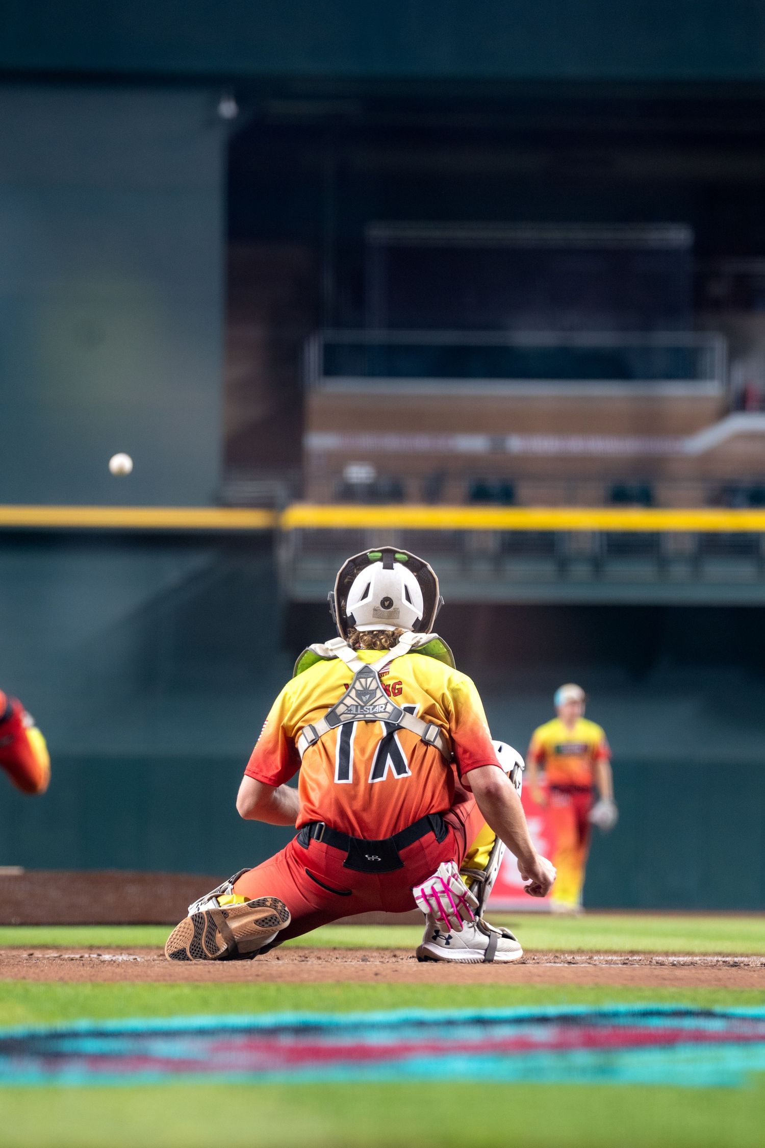 Baseball player sprawls on the ground after diving for a ball during a game.