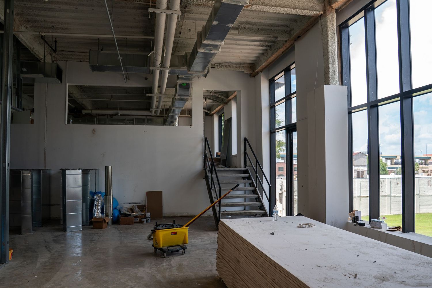 Commercial building interior with floor-to-ceiling windows and ongoing construction work.
