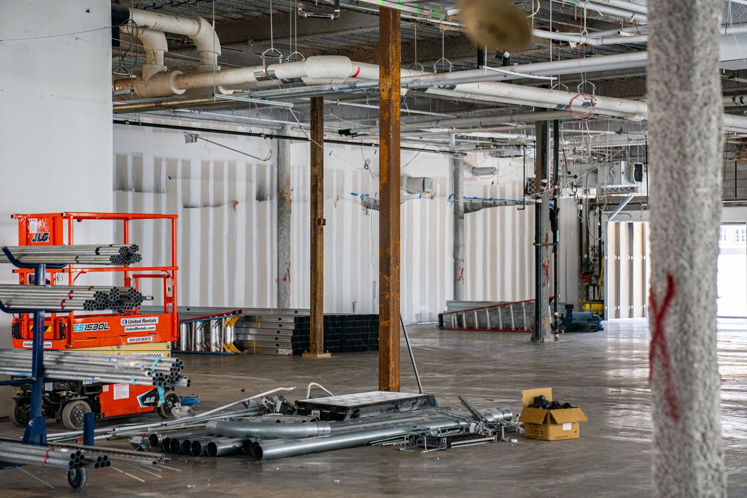 Industrial warehouse under renovation showing construction equipment and building materials.