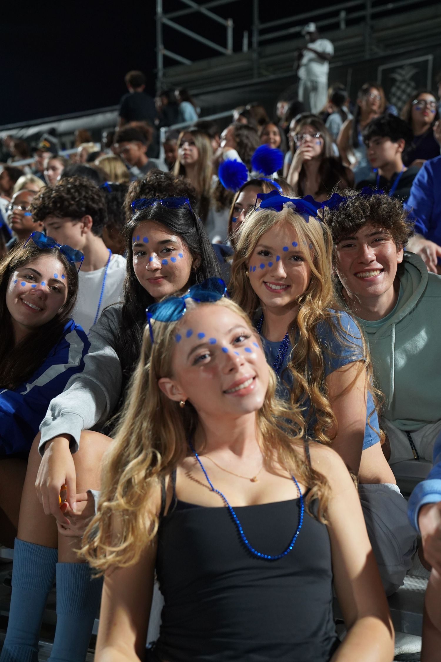 Students wearing blue accessories and casual attire seated together in an auditorium.