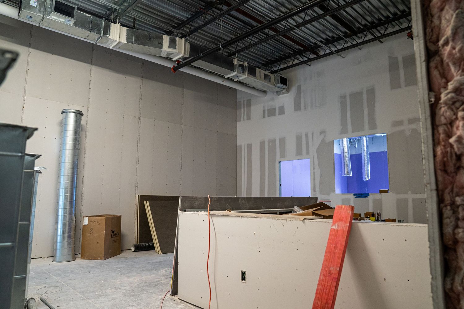 Unfinished room with blue-lit doorway and metal ductwork visible in ceiling.