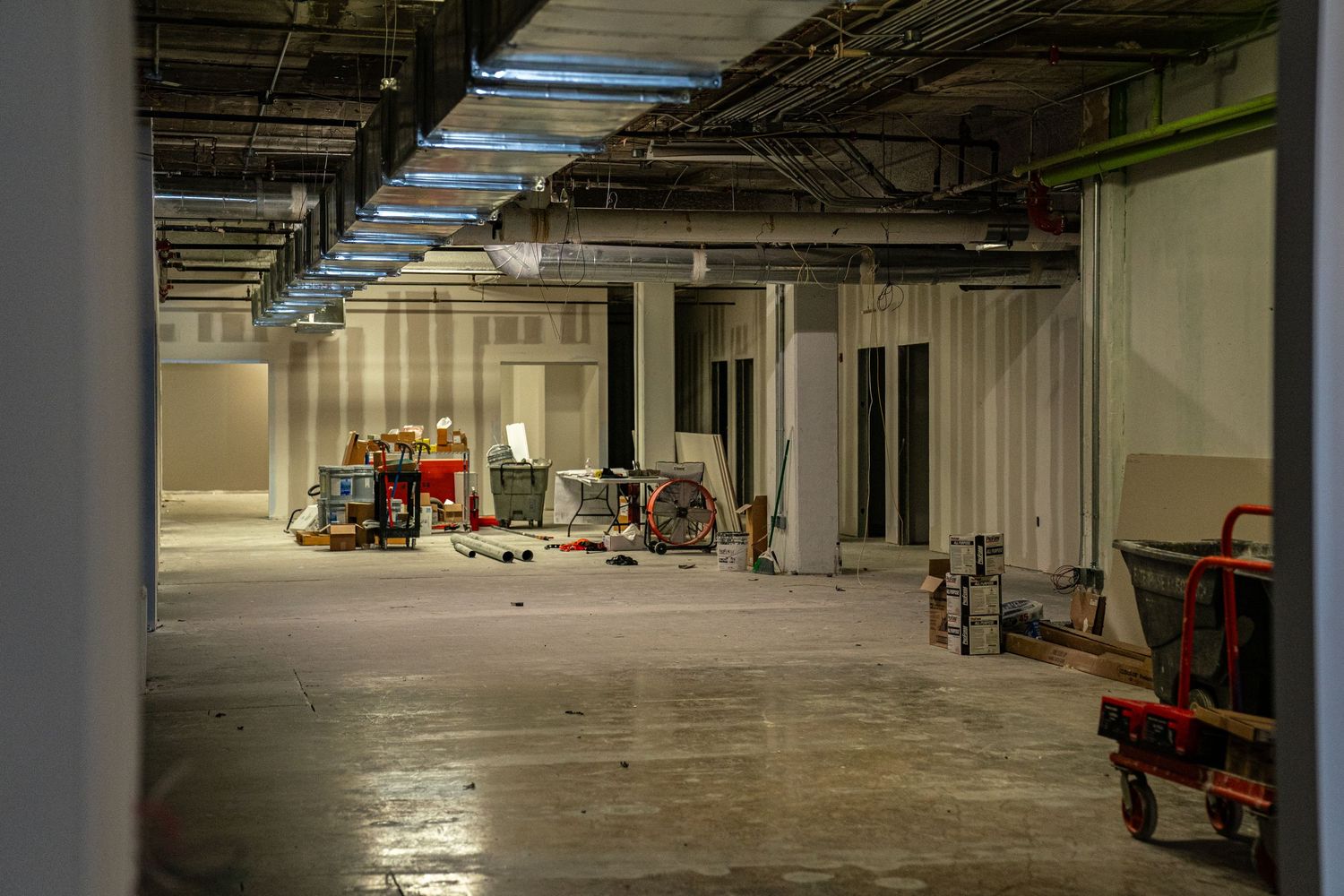 Spacious industrial warehouse area with concrete floors and utility carts visible.