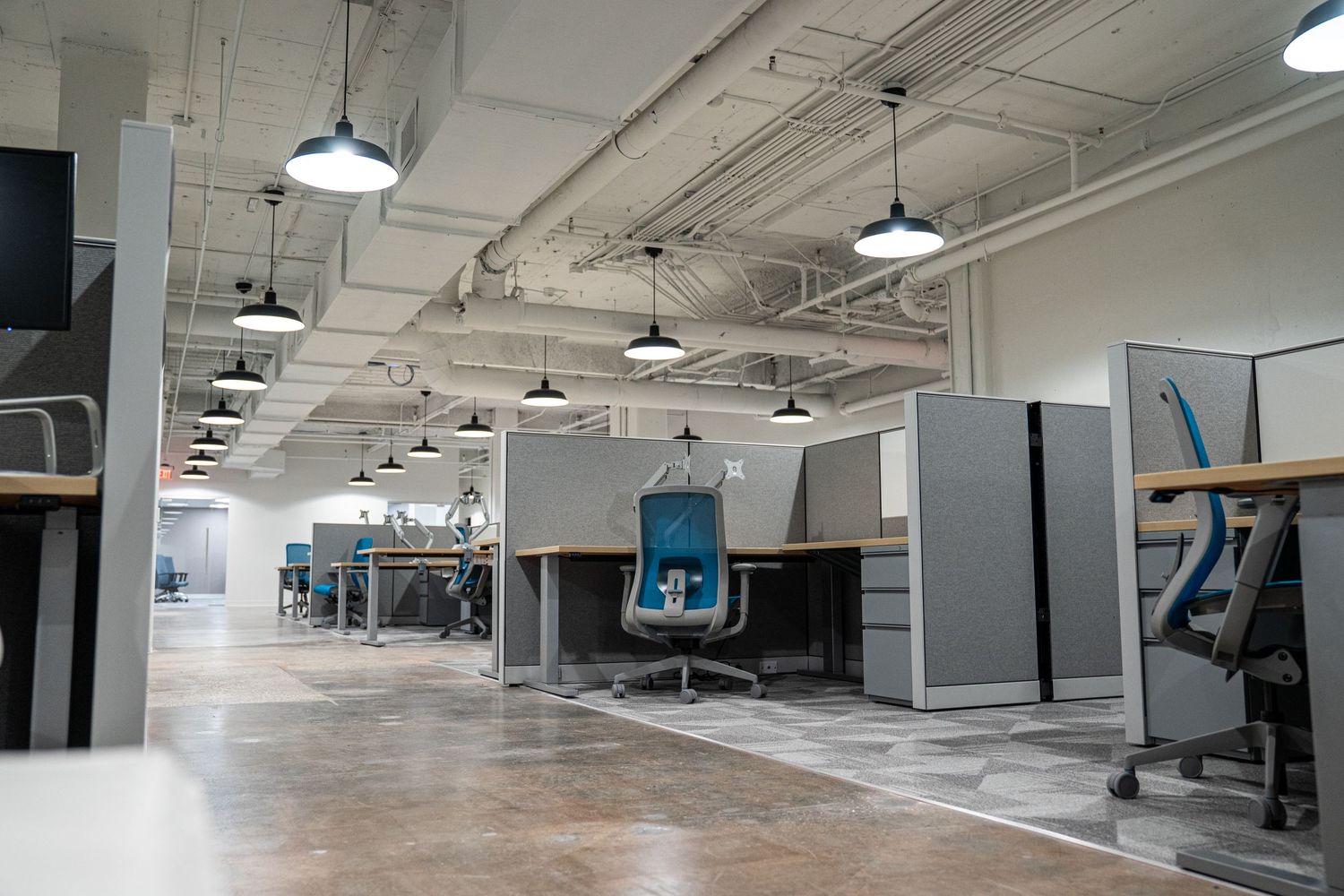 Modern office buildout showing industrial ceiling design and open floor plan layout.