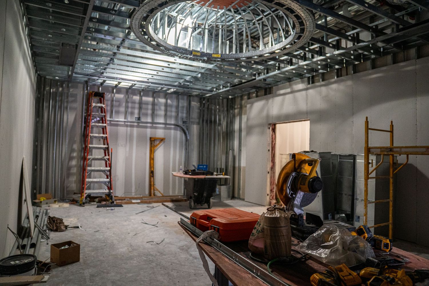 Construction site showing circular ceiling detail and various building materials and equipment.
