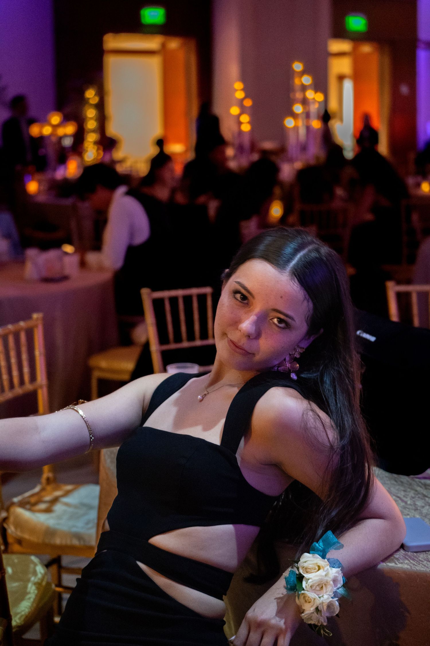 Formal event setting with purple lighting and white chairs in an elegant reception hall.