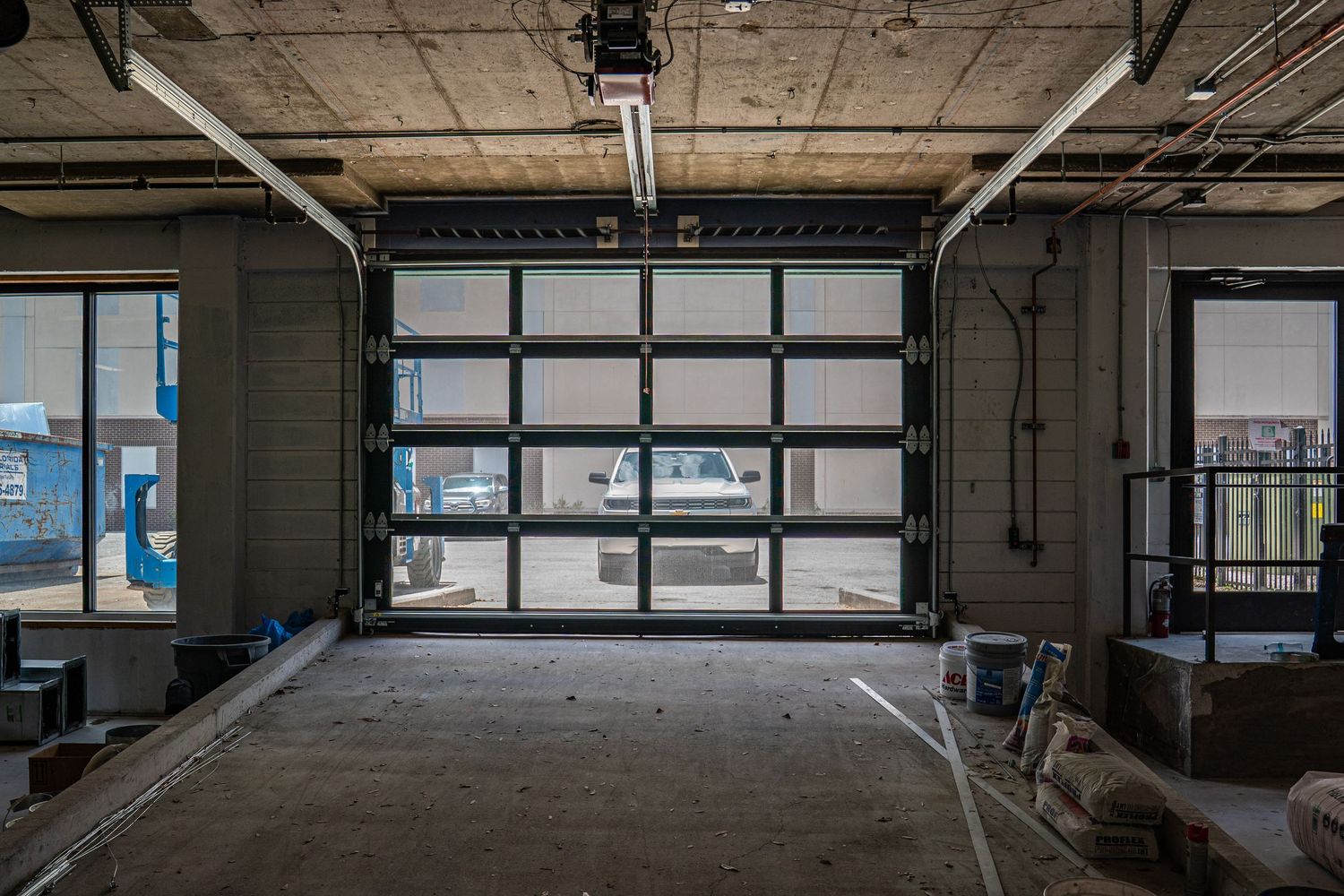 Wide commercial space with floor-to-ceiling windows and exposed industrial ceiling.