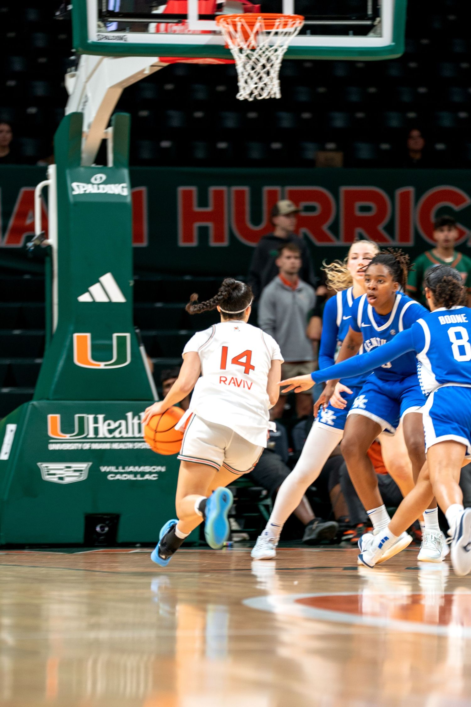 Players from both teams scramble on the floor for possession during a competitive basketball match.