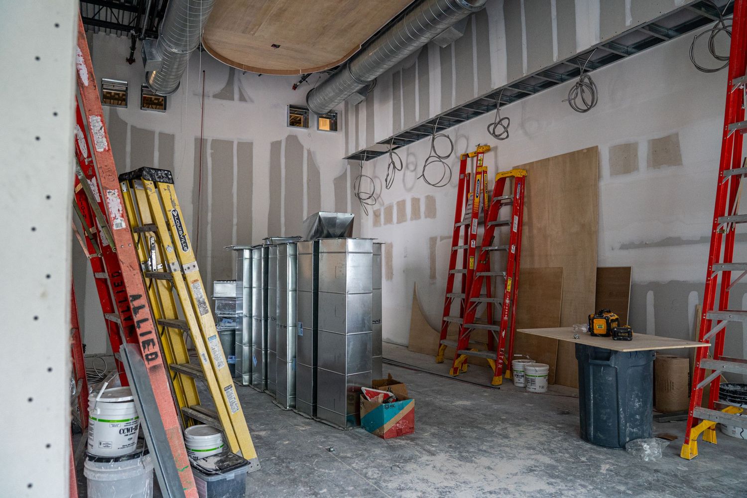 Industrial space under construction showing metal framing and utility installations.