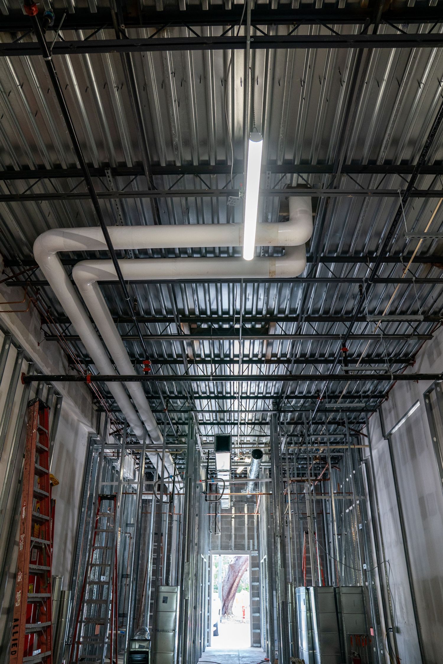 Interior construction site showing metal ceiling framework and ductwork in a commercial building renovation.