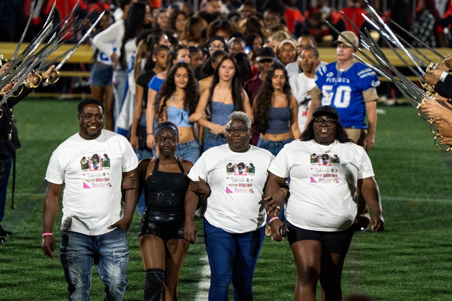 Group of students walking together on a grassy field during an outdoor event.