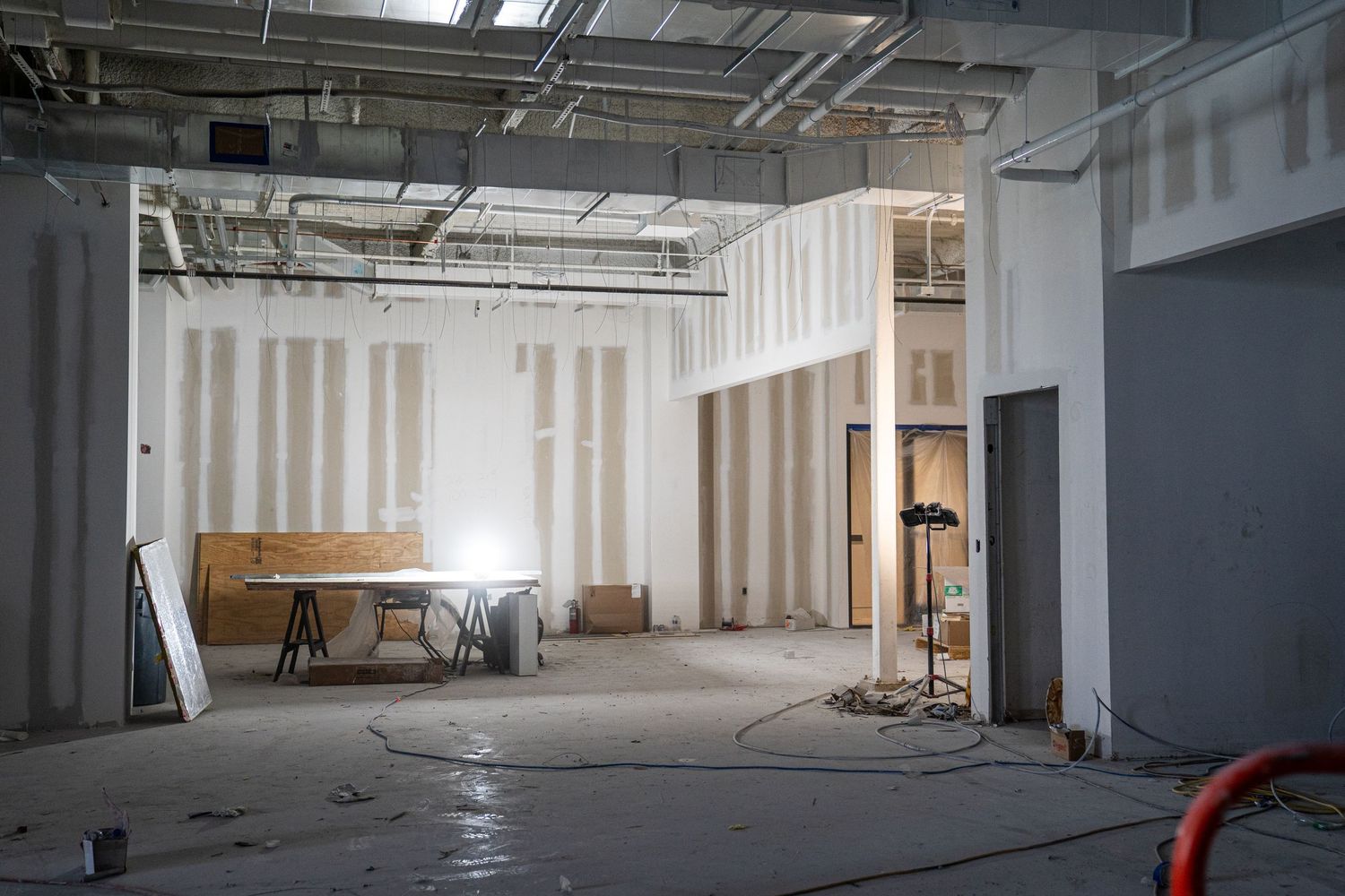 Large empty industrial warehouse space under construction with exposed ceiling and concrete floors.