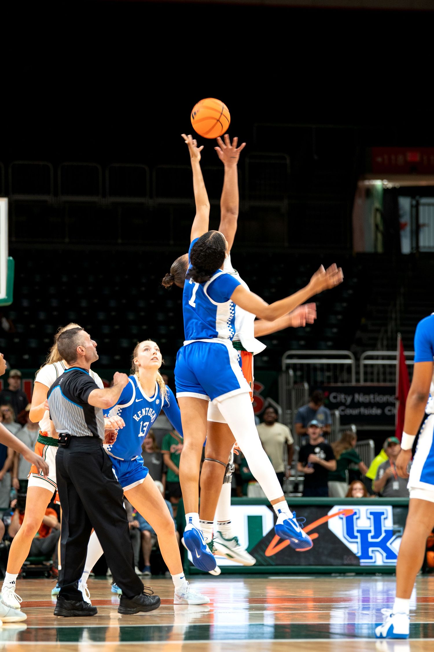 Basketball players jumping for rebound during competitive game.