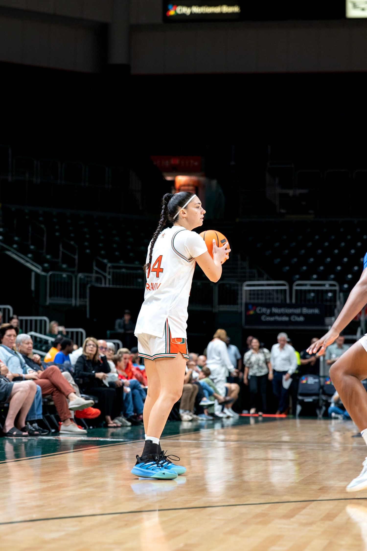 Basketball players perform warmup exercises on the hardwood court.