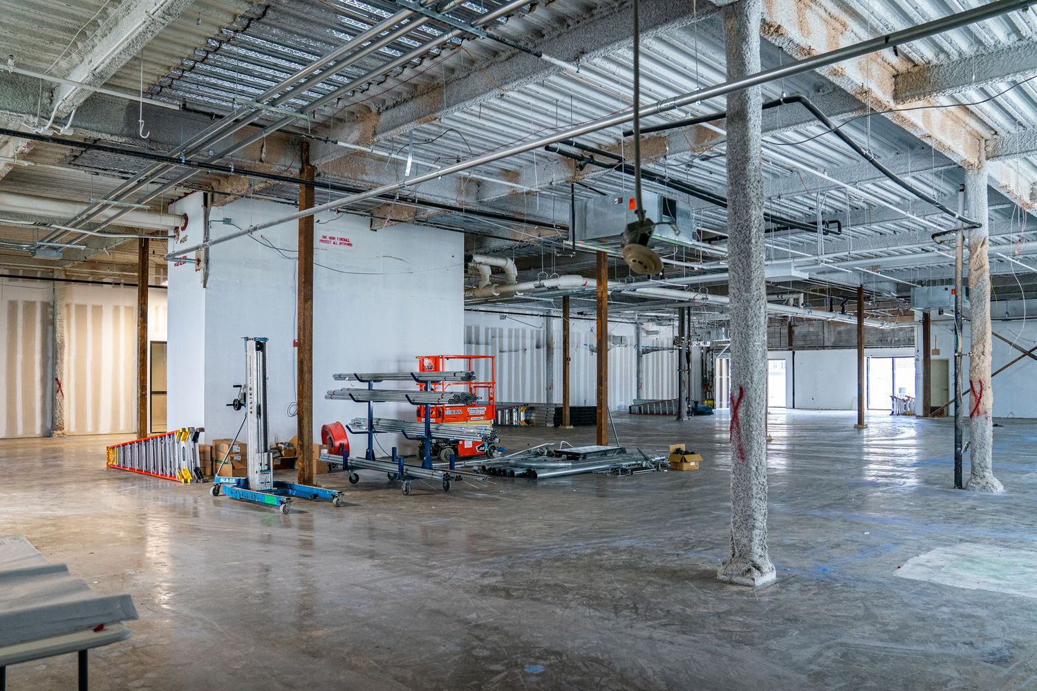 Large unfinished commercial space with industrial features and natural lighting.