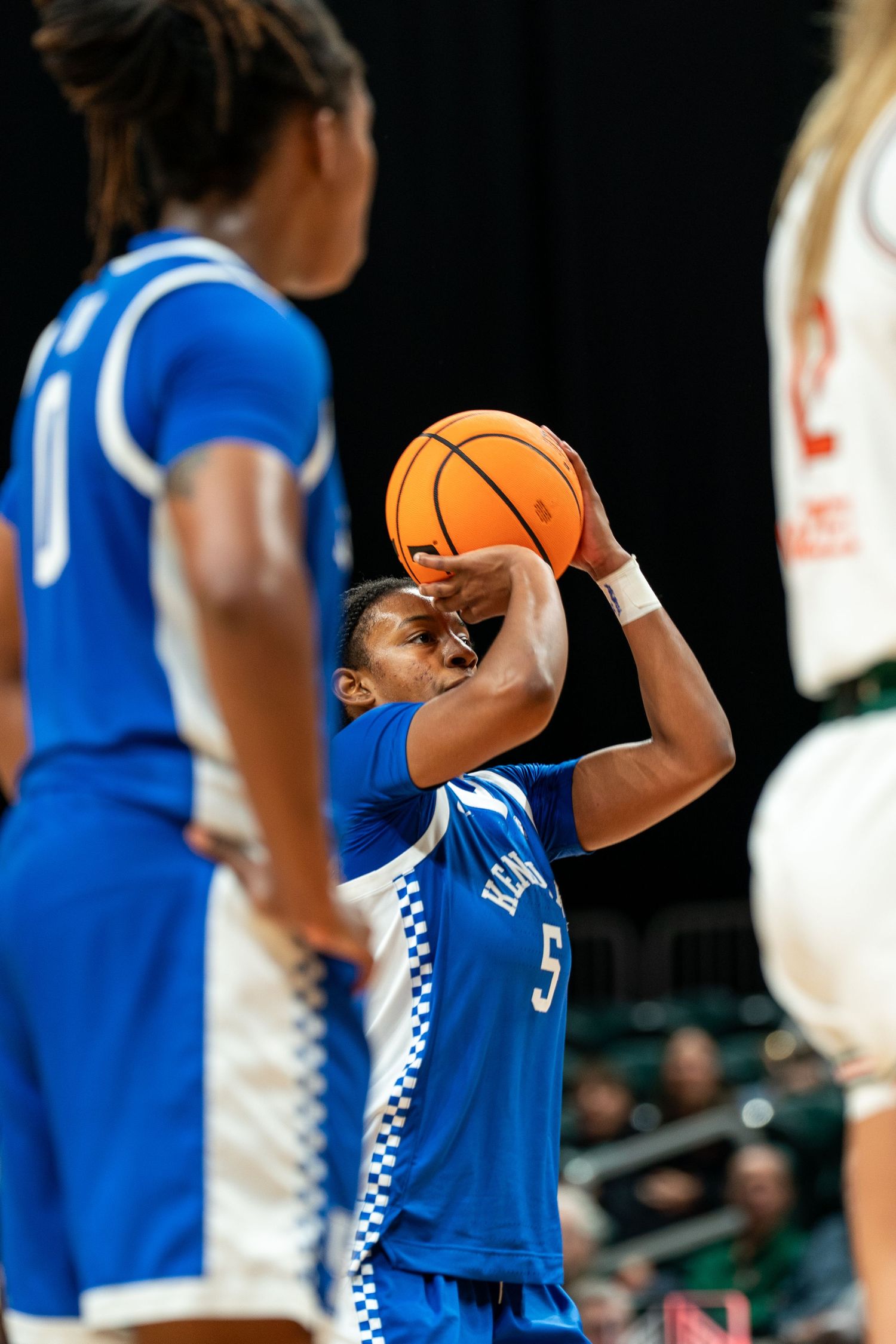 Basketball player in blue uniform shooting the ball during game.
