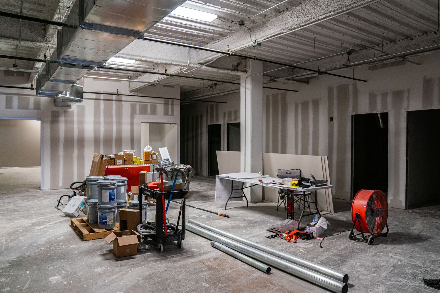Commercial building interior during renovation with construction supplies and equipment visible.