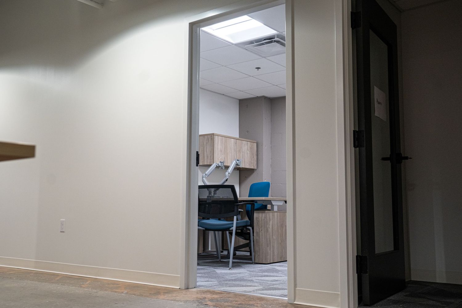 Bright commercial hallway with white walls and doorways under construction.