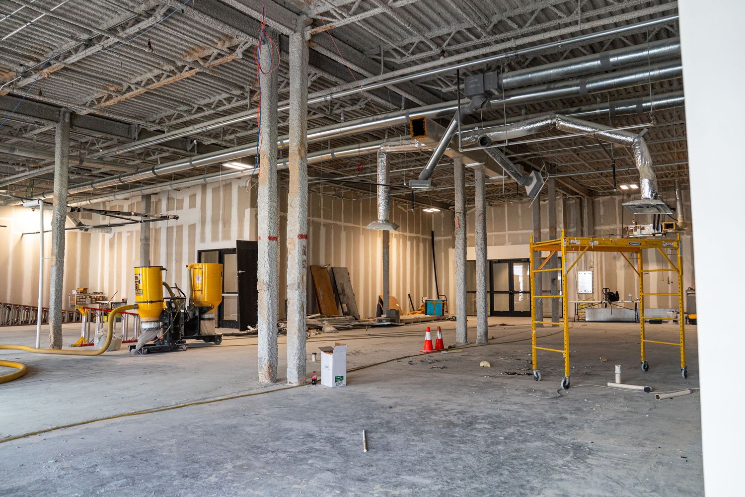 Warehouse renovation space with concrete floors and exposed structural elements throughout.