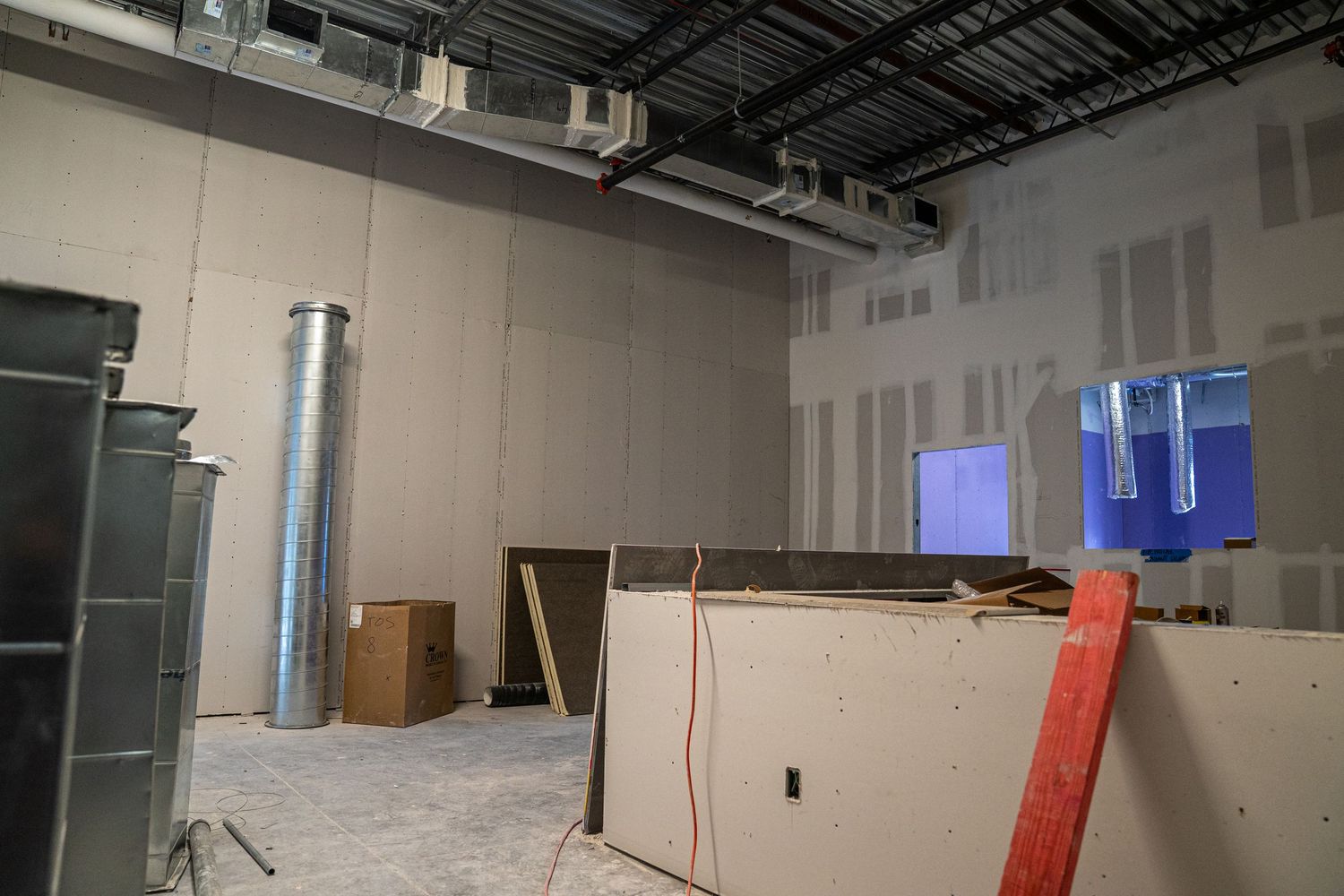 Wide view of commercial renovation showing framed walls and exposed mechanical systems.
